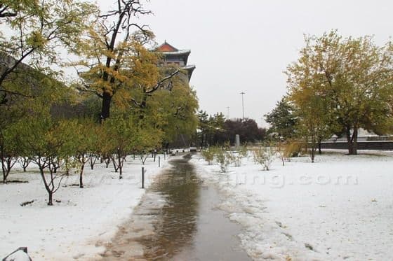 The Arrow Tower is hidden behind the atumn leaves with the early winter snow on the ground