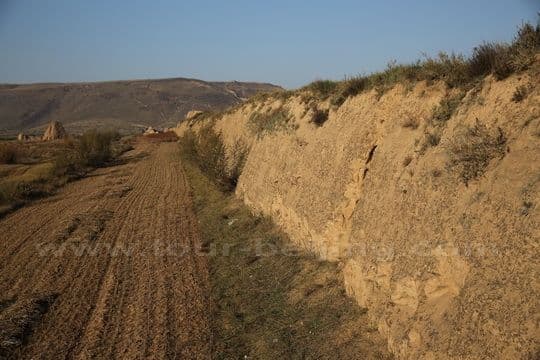 The earth Wall is sandwiched by the fields on the both sides.